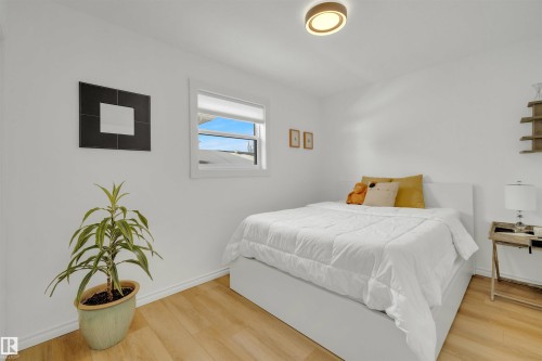 This room features light-colored flooring, a window providing natural light, and a modern ceiling light fixture - 131 West Liberty Crescent, Millet, AB - Indoor Photo Showing Bedroom