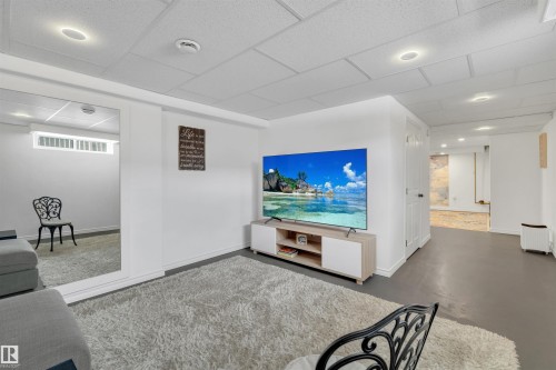This inviting recreation space features white walls, recessed lighting, and a drop ceiling - 131 West Liberty Crescent, Millet, AB - Indoor