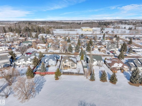Aerial view of the property and surrounding neighborhood, featuring a residential area with varied home styles and mature trees - 131 West Liberty Crescent, Millet, AB - Outdoor With View
