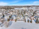Aerial view of the property and surrounding neighborhood, featuring a residential area with varied home styles and mature trees - 131 West Liberty Crescent, Millet, AB  - Outdoor With View 