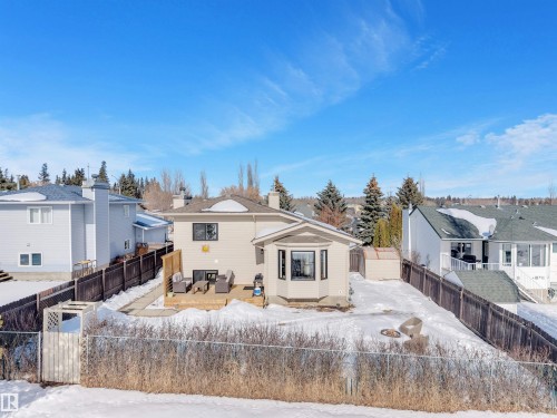 The property features a large rear deck with outdoor seating and a fire pit, a shed, and a fenced yard - 131 West Liberty Crescent, Millet, AB - Outdoor