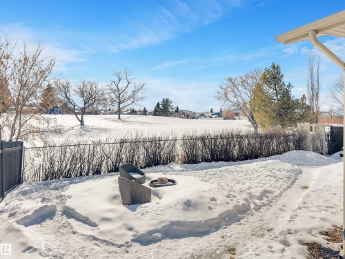 The property features a fenced yard with an outdoor patio area, a privacy screen, and a view of a snow-covered field - 131 West Liberty Crescent, Millet, AB - Outdoor