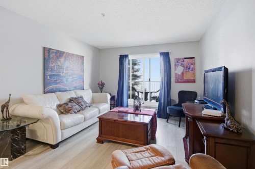 The living area features light-toned flooring and a sliding glass door providing external access - 115 2208 44 Avenue, Edmonton, AB - Indoor Photo Showing Living Room