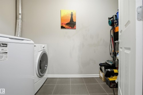 Dedicated laundry area featuring a white washing machine and a white dryer - 115 2208 44 Avenue, Edmonton, AB - Indoor Photo Showing Laundry Room