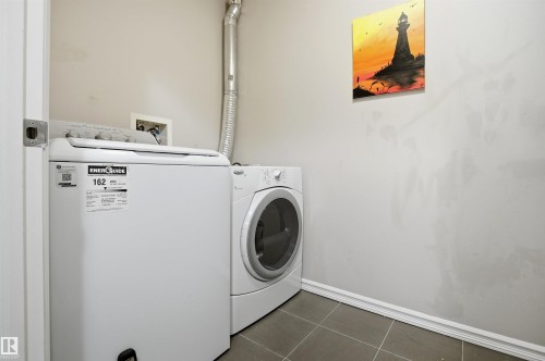 Utility area featuring tile flooring, neutral wall paint, and laundry appliances - 115 2208 44 Avenue, Edmonton, AB - Indoor Photo Showing Laundry Room