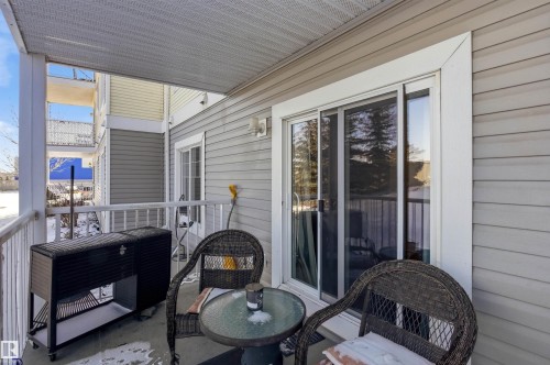 The property features a covered balcony with a sliding glass door and white railings - 115 2208 44 Avenue, Edmonton, AB - Outdoor With Deck Patio Veranda With Exterior