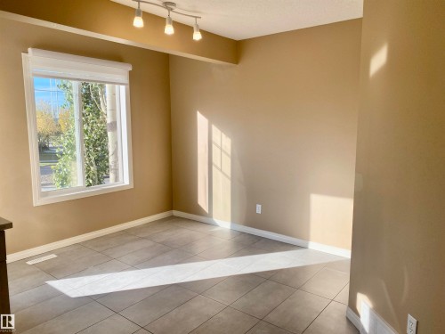Empty room with light tile patterned flooring and rail lighting - 403 178 Bridgeport Boulevard, Leduc, AB - Indoor Photo Showing Other Room