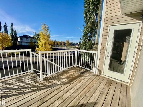 Wooden deck featuring a residential view - 403 178 Bridgeport Boulevard, Leduc, AB - Outdoor With Deck Patio Veranda With Exterior