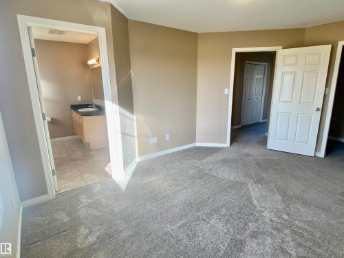 Unfurnished bedroom with light carpet and ensuite bath - 403 178 Bridgeport Boulevard, Leduc, AB - Indoor