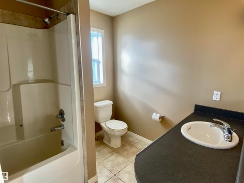 Full bath featuring vanity, tub / shower combination, and light tile patterned floors - 403 178 Bridgeport Boulevard, Leduc, AB - Indoor Photo Showing Bathroom