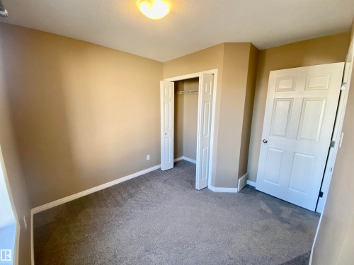 Unfurnished bedroom with light colored carpet and a closet - 403 178 Bridgeport Boulevard, Leduc, AB - Indoor Photo Showing Other Room