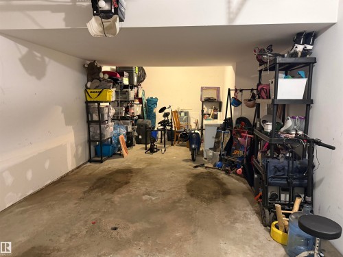 The garage features a concrete floor and white walls, offering a functional space - 403 178 Bridgeport Boulevard, Leduc, AB - Indoor Photo Showing Garage