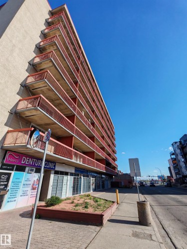 The property features a multi-story building with balconies, and ground-level commercial units - Edmonton, AB - Outdoor