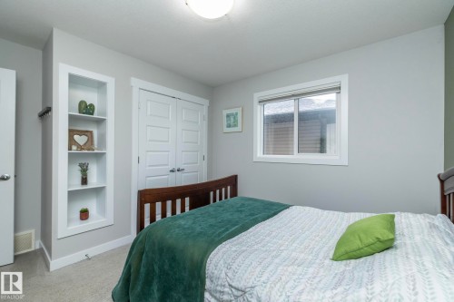 This room features light grey walls, a window with blinds, and built-in shelving - 7608 179 Avenue, Edmonton, AB - Indoor Photo Showing Bedroom