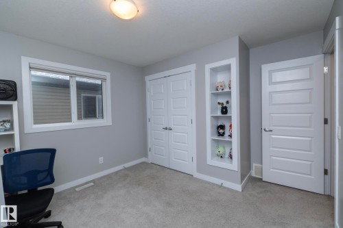 The room features light gray walls, a window with white trim, and a built-in recessed shelving unit - 7608 179 Avenue, Edmonton, AB - Indoor