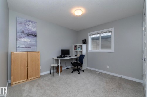 This room features light grey walls, light grey carpeting, and a window providing natural light - 7608 179 Avenue, Edmonton, AB - Indoor Photo Showing Office