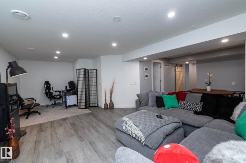 Spacious living area featuring light-toned flooring, recessed lighting, and a barn door - 7608 179 Avenue, Edmonton, AB - Indoor