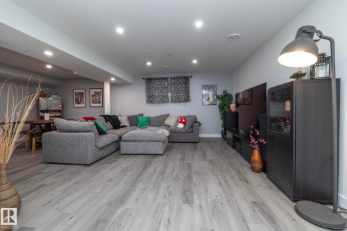 Spacious living area featuring light-toned flooring, recessed lighting, and a large window - 7608 179 Avenue, Edmonton, AB - Indoor
