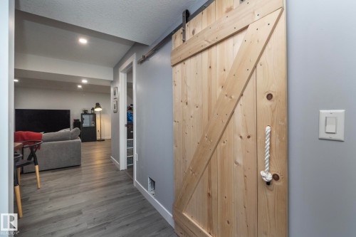 Interior space featuring a barn door with a rope handle, recessed lighting, and grey flooring - 7608 179 Avenue, Edmonton, AB - Indoor Photo Showing Other Room