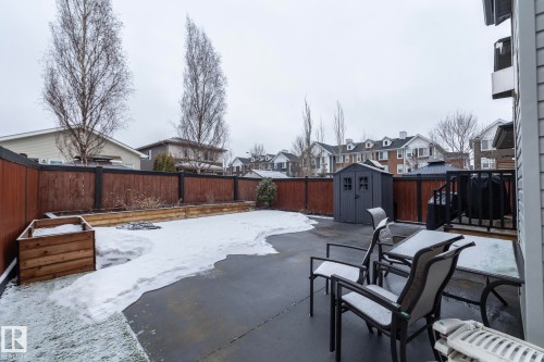 The property features a fenced yard with a concrete patio, a wooden planter box, and a storage shed - 7608 179 Avenue, Edmonton, AB - Outdoor