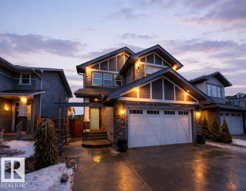 The property features a two-car garage, a stone facade, and exterior lighting - 7608 179 Avenue, Edmonton, AB - Outdoor With Facade