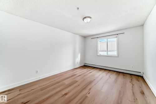This room features light wood-look flooring, white walls, and a window providing natural light - 126 16221 95 Street, Edmonton, AB - Indoor Photo Showing Other Room
