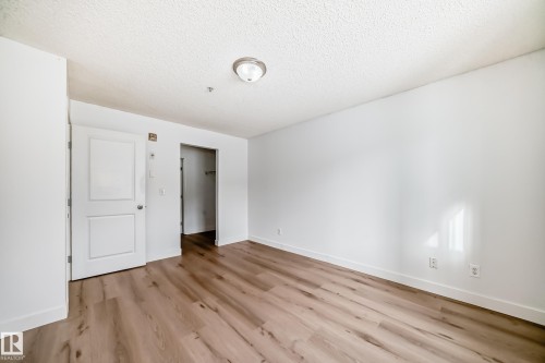 This room features light-colored walls and wood-style flooring, creating a bright and inviting atmosphere - 126 16221 95 Street, Edmonton, AB - Indoor Photo Showing Other Room