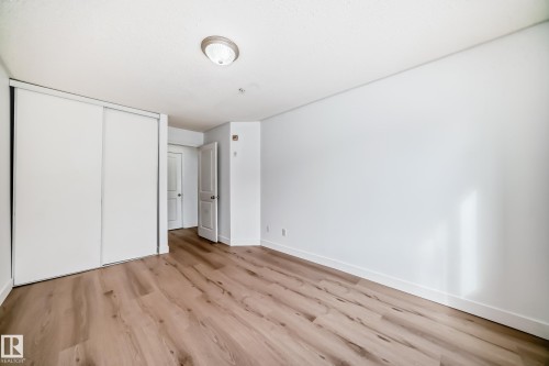 This room features light wood-style flooring and white walls, creating a bright and airy atmosphere - 126 16221 95 Street, Edmonton, AB - Indoor Photo Showing Other Room