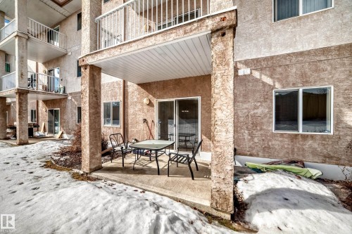 The property features a private covered patio with a concrete surface, providing an outdoor seating area - 126 16221 95 Street, Edmonton, AB - Outdoor With Exterior