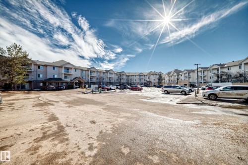 The property features a multi-story building with a light-colored exterior and dark-toned roofing - 126 16221 95 Street, Edmonton, AB - Outdoor