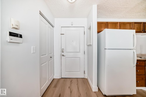 Entryway featuring wood laminate flooring and a white paneled door - 126 16221 95 Street, Edmonton, AB - Indoor