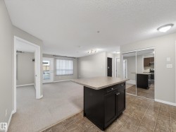 The property features a kitchen with dark cabinetry, a range, and a refrigerator, complemented by tile flooring - 