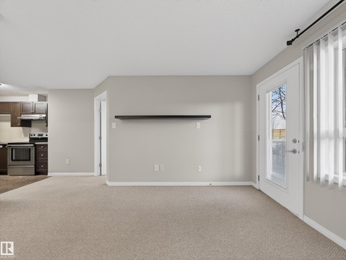 The open concept living area features light-colored carpeting and neutral painted walls - 1111 9363 Simpson Drive, Edmonton, AB - Indoor