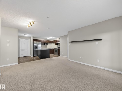 Open concept living space featuring carpeted flooring and light grey walls - 1111 9363 Simpson Drive, Edmonton, AB - Indoor