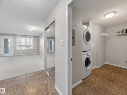 This property features an in-unit stacked washer and dryer, tiled flooring, and a wire shelving unit - 