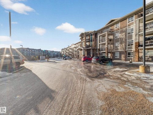 The property features a multi-story building with balconies and a parking area in front - 1111 9363 Simpson Drive, Edmonton, AB - Outdoor With Facade