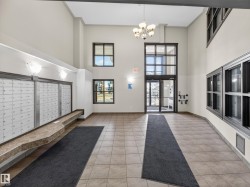 The property features a spacious entryway with tile flooring, high ceilings, large windows, and a classic chandelier - 