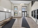 The property features a spacious entryway with tile flooring, high ceilings, large windows, and a classic chandelier - 1111 9363 Simpson Drive, Edmonton, AB  - Indoor Photo Showing Other Room 