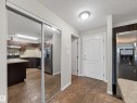 The entry features tiled flooring, a white paneled door, and a mirrored closet - 1111 9363 Simpson Drive, Edmonton, AB  - Indoor Photo Showing Kitchen 