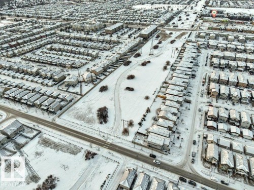 Aerial view of a residential area featuring detached properties and townhomes, with streets and open land visible - 1912 27 Street Nw, Edmonton, AB - Outdoor