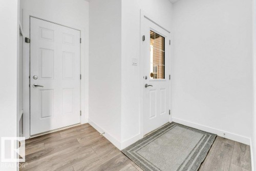 Entryway featuring light-toned flooring, white walls, and a door with a clear glass panel - 1912 27 Street Nw, Edmonton, AB - Indoor Photo Showing Other Room
