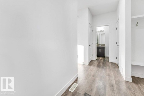 Hallway featuring light-colored walls and wood-look flooring - 1912 27 Street Nw, Edmonton, AB - Indoor Photo Showing Other Room