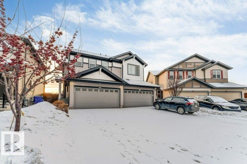 The property features a two-car garage, a light-colored exterior with dark trim, and a prominent gable roofline - 1912 27 Street Nw, Edmonton, AB - Outdoor With Facade