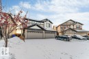 The property features a two-car garage, a light-colored exterior with dark trim, and a prominent gable roofline - 1912 27 Street Nw, Edmonton, AB  - Outdoor With Facade 