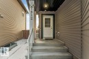 The property features light brown horizontal siding and a white front door with windowpanes - 1912 27 Street Nw, Edmonton, AB  - Outdoor With Exterior 
