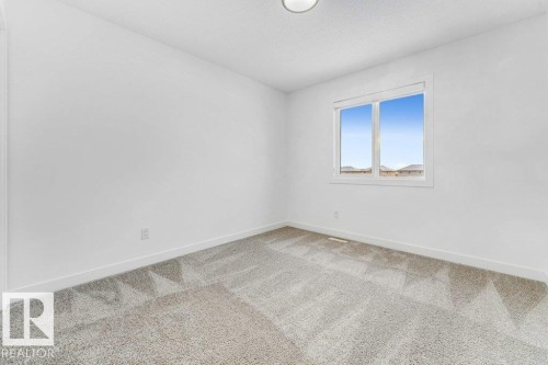 The room features a window providing natural light, light-toned carpeting, and a ceiling light fixture - 1912 27 Street Nw, Edmonton, AB - Indoor Photo Showing Other Room