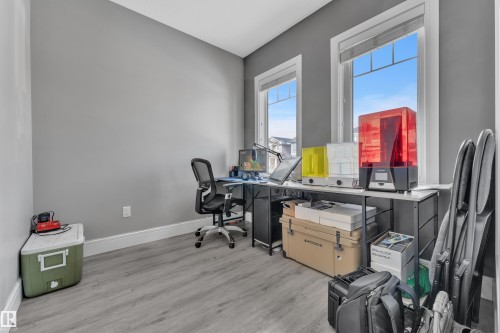 This room features two windows providing natural light, a neutral grey wall color, and light-toned flooring - 195 Kirpatrick Way, Leduc, AB - Indoor Photo Showing Office