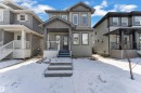The property features a gray exterior with white trim, a covered front porch, and a dark front door - 195 Kirpatrick Way, Leduc, AB  - Outdoor With Facade 