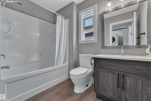 Bathroom featuring a white tub and shower combination, a toilet, and a vanity with a white countertop and dark wood-look cabinetry - 195 Kirpatrick Way, Leduc, AB - Indoor Photo Showing Bathroom