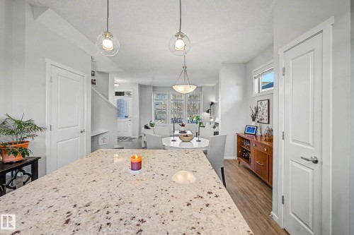 Dining space featuring dark wood-style flooring, plenty of natural light, and a textured ceiling - 4110 Allan Crescent, Edmonton, AB - Indoor